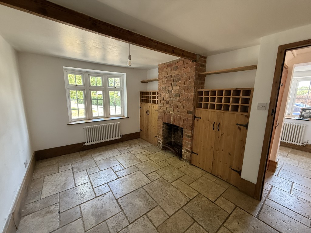 Lot: 168 - DETACHED COTTAGE IN ESSEX VILLAGE LOCATION - Dining room with window to front fireplace, storage and wine racking